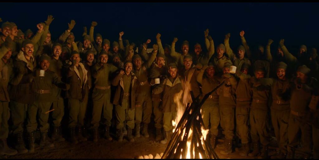 The visuals then shift to Farhan Akhtar as Major Shaitan Singh, standing tall before his troops. In a stirring moment, he delivers an inspiring speech, reminding his soldiers that they are sons of farmers—born to protect their soil. With passion and pride, he declares that this battle isn’t merely for land, but for their beloved motherland.